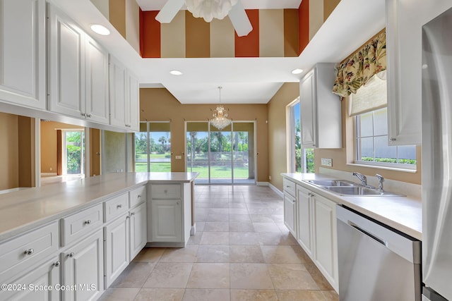 kitchen featuring kitchen peninsula, appliances with stainless steel finishes, sink, decorative light fixtures, and white cabinetry