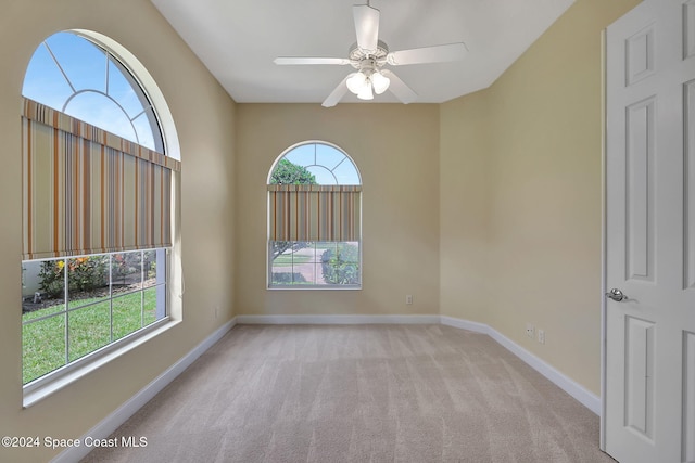 carpeted spare room with ceiling fan