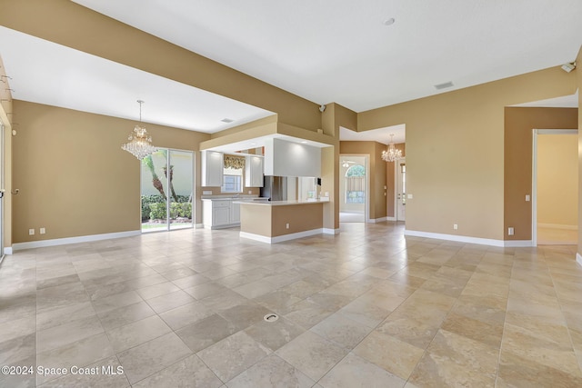 unfurnished living room with an inviting chandelier