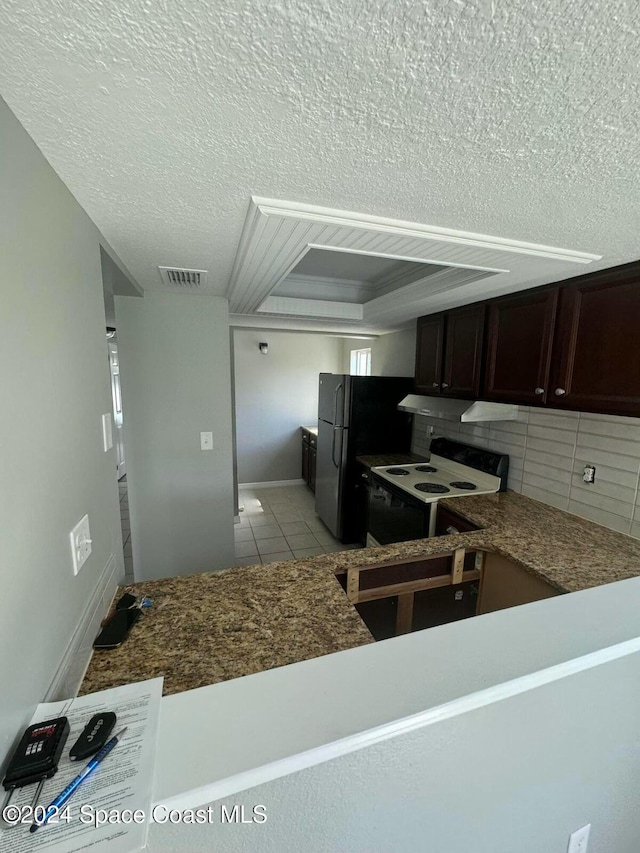 kitchen featuring black refrigerator, decorative backsplash, dark brown cabinets, a textured ceiling, and white electric range