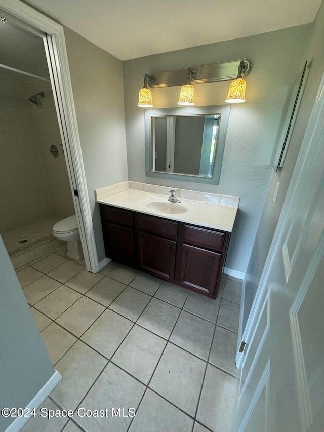 bathroom with tile patterned floors, toilet, vanity, and walk in shower