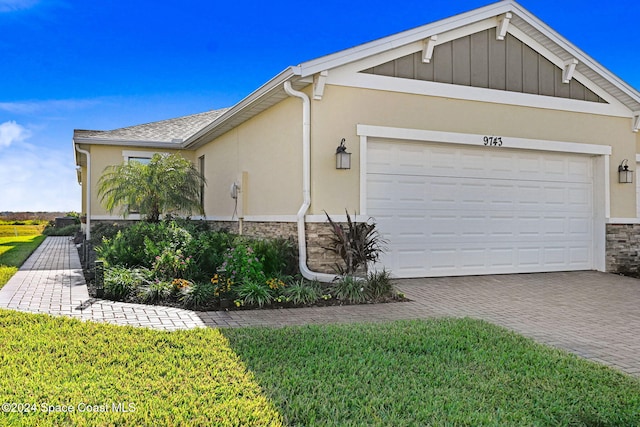 view of property exterior featuring a garage and a lawn