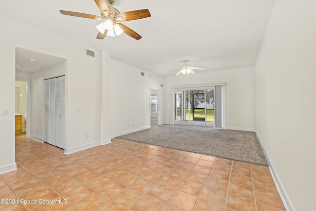 spare room featuring light colored carpet and ceiling fan