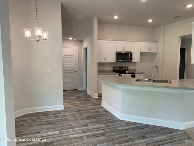 439 Wellwood St SW, Palm Bay, FL 32908 - kitchen featuring stainless steel appliances, dark wood-style floors, white cabinetry, recessed lighting, and a chandelier
