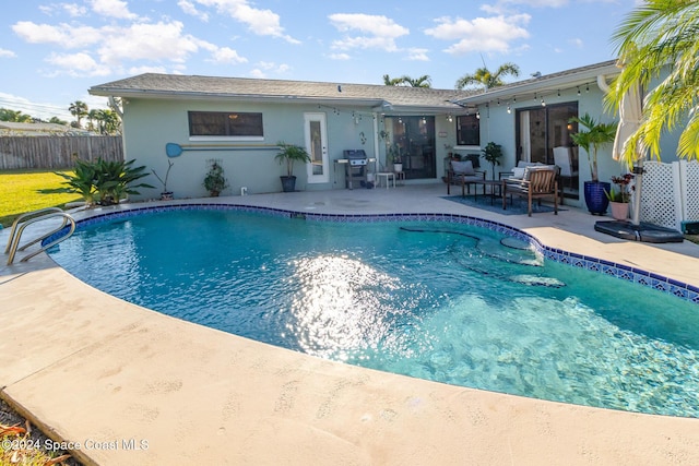 view of swimming pool featuring a patio and a grill