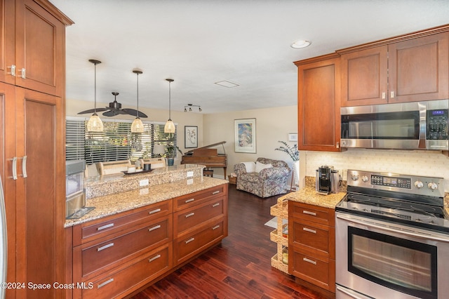 kitchen featuring decorative backsplash, light stone counters, stainless steel appliances, decorative light fixtures, and dark hardwood / wood-style floors