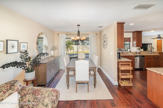 dining room with dark hardwood / wood-style flooring and an inviting chandelier