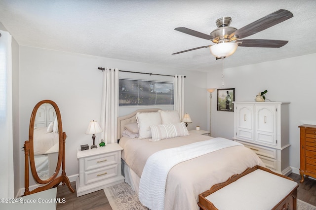 bedroom with a textured ceiling, ceiling fan, and dark hardwood / wood-style floors