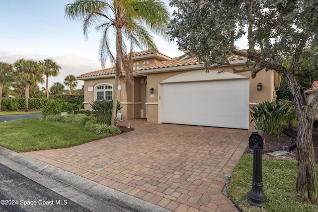 mediterranean / spanish-style home with a garage and a front yard