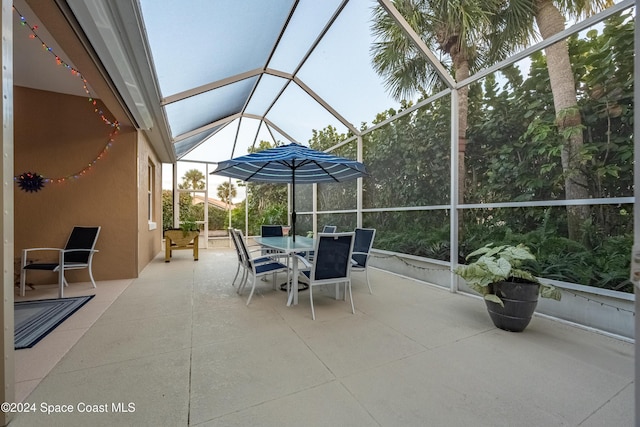 view of patio featuring glass enclosure