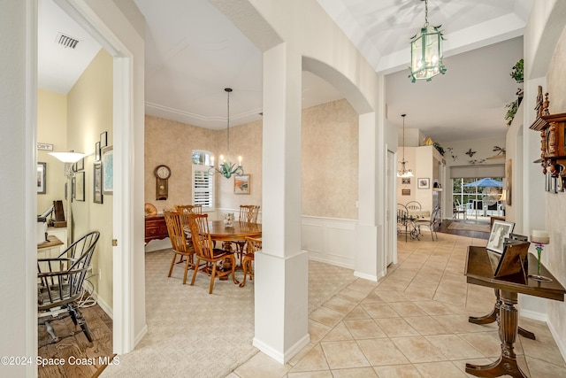 carpeted entryway with a notable chandelier