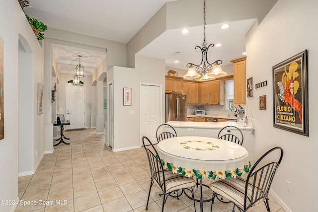 dining area featuring a chandelier, sink, and light tile patterned flooring