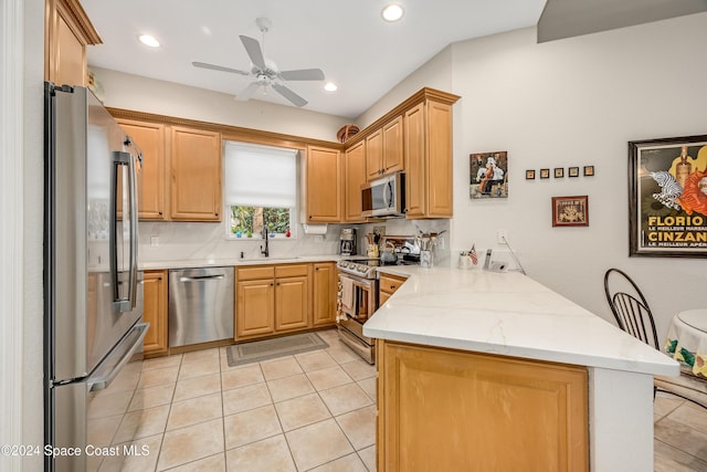 kitchen with sink, ceiling fan, light stone countertops, kitchen peninsula, and stainless steel appliances