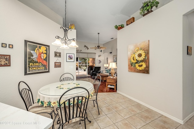 dining room featuring ceiling fan with notable chandelier and light tile patterned flooring