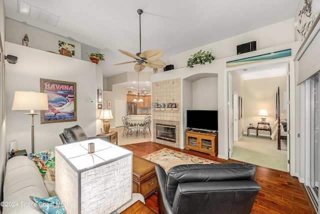 living room featuring hardwood / wood-style floors, ceiling fan, and a tiled fireplace