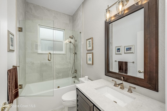 full bathroom with shower / bath combination with glass door, vanity, and toilet