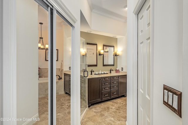 bathroom with tiled bath, crown molding, vanity, and a notable chandelier