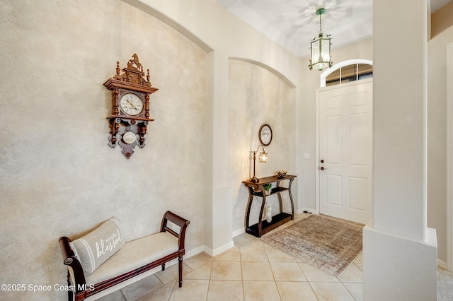 5601 Sea Lavender Pl, Melbourne Beach, FL 32951 - foyer featuring a chandelier, light tile patterned floors, and arched walkways