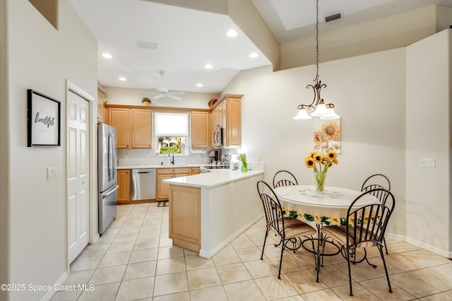 5601 Sea Lavender Pl, Melbourne Beach, FL 32951 - kitchen featuring appliances with stainless steel finishes, a peninsula, light countertops, light brown cabinets, and recessed lighting