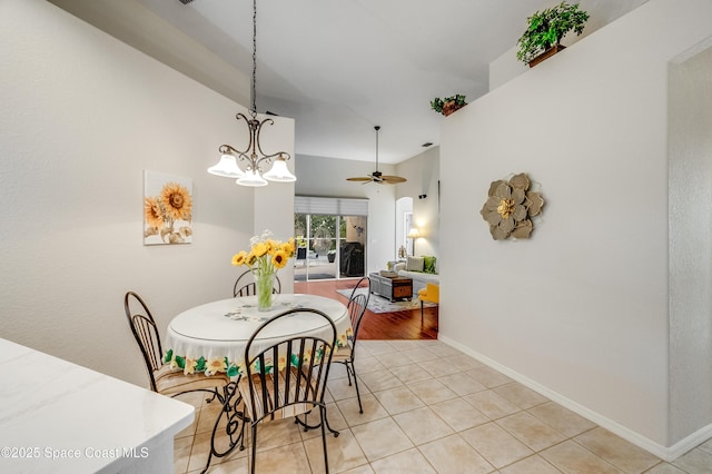 5601 Sea Lavender Pl, Melbourne Beach, FL 32951 - dining room featuring light tile patterned floors, baseboards, a ceiling fan, and a chandelier