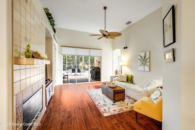 5601 Sea Lavender Pl, Melbourne Beach, FL 32951 - living area with arched walkways, ceiling fan, wood finished floors, a tiled fireplace, and high vaulted ceiling
