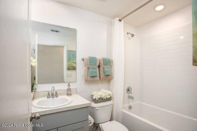 full bathroom with vanity, shower / tub combo, and toilet