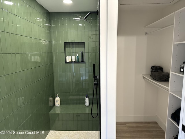 bathroom featuring hardwood / wood-style floors and tiled shower