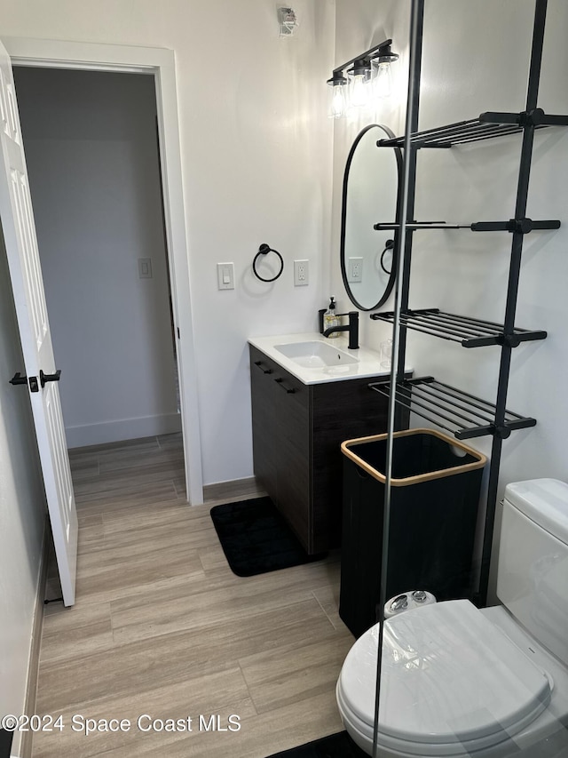 bathroom with vanity, hardwood / wood-style flooring, and toilet