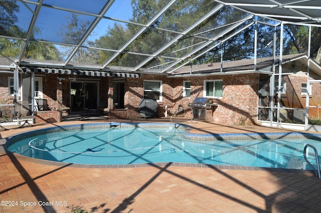 view of pool featuring area for grilling, a patio, and glass enclosure