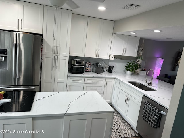 kitchen featuring stainless steel refrigerator with ice dispenser, dishwashing machine, kitchen peninsula, light stone countertops, and white cabinets