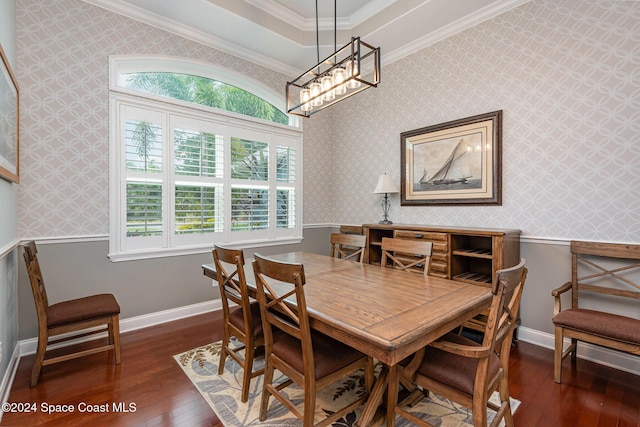 dining room featuring a tray ceiling, an inviting chandelier, dark wood-type flooring, and ornamental molding