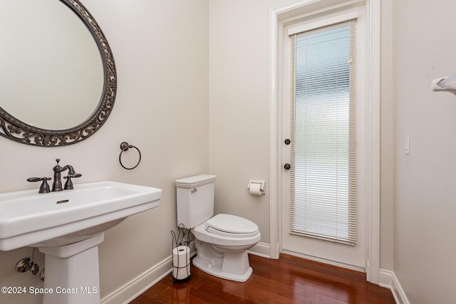 bathroom featuring hardwood / wood-style flooring, toilet, and sink