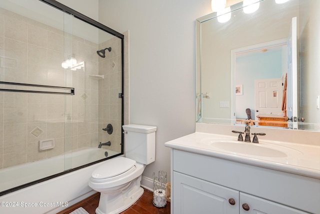 full bathroom featuring shower / bath combination with glass door, wood-type flooring, vanity, and toilet