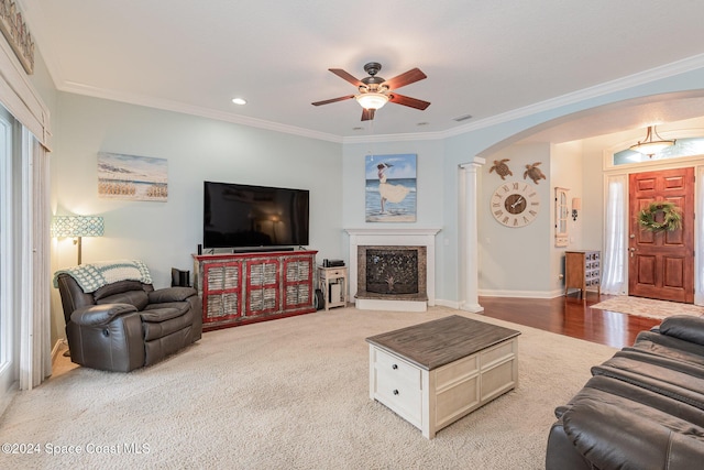 carpeted living room featuring ceiling fan, ornamental molding, and ornate columns