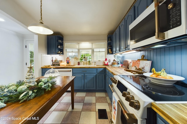 kitchen featuring decorative light fixtures, a healthy amount of sunlight, blue cabinetry, and wooden counters