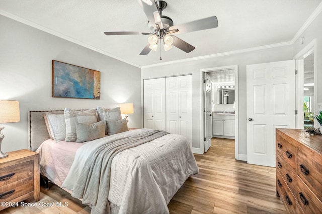 bedroom featuring ceiling fan, light wood-type flooring, crown molding, and a closet