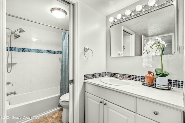 full bathroom featuring vanity, a textured ceiling, toilet, and shower / tub combo with curtain