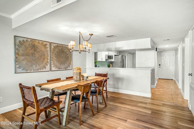 dining space featuring a chandelier, crown molding, light hardwood / wood-style floors, and a textured ceiling