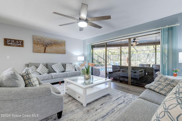 living room with ceiling fan, plenty of natural light, and light hardwood / wood-style floors