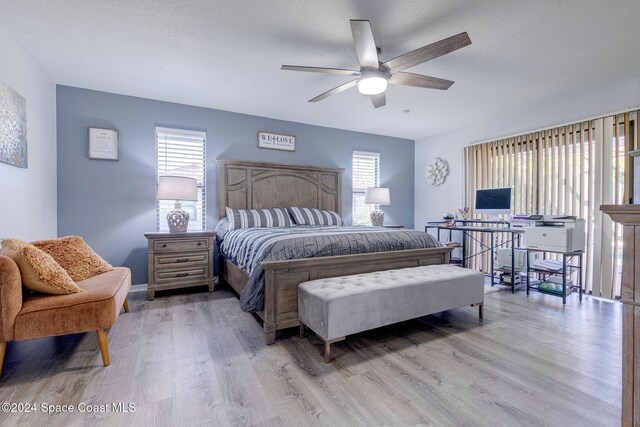 bedroom featuring ceiling fan, a textured ceiling, and light hardwood / wood-style flooring