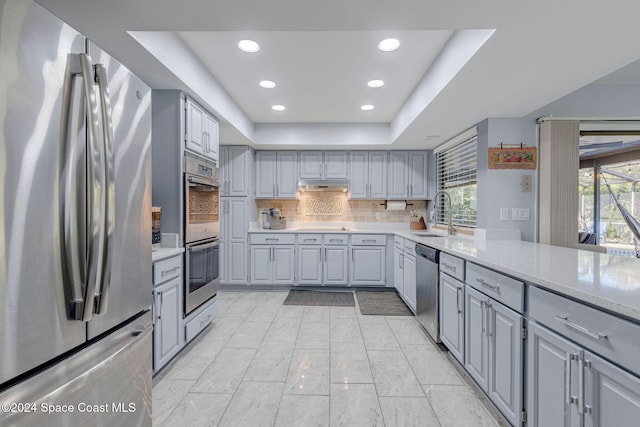 kitchen featuring appliances with stainless steel finishes, gray cabinets, and a healthy amount of sunlight