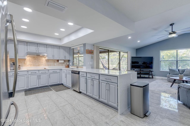 kitchen with gray cabinetry, stainless steel dishwasher, ceiling fan, decorative backsplash, and kitchen peninsula