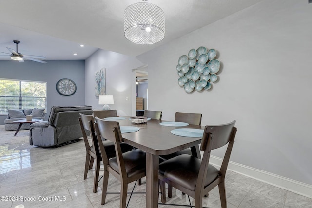 tiled dining space featuring ceiling fan with notable chandelier