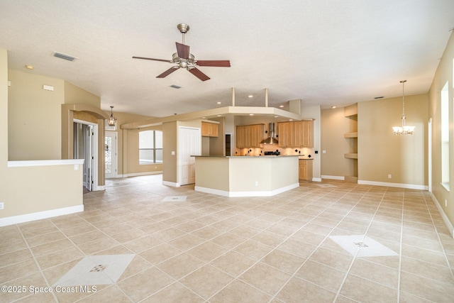 unfurnished living room featuring ceiling fan with notable chandelier, light tile patterned floors, and a textured ceiling