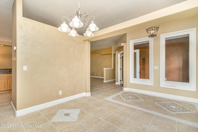 unfurnished room with light tile patterned floors and an inviting chandelier