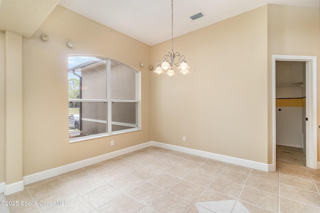 spare room featuring light tile patterned flooring and an inviting chandelier