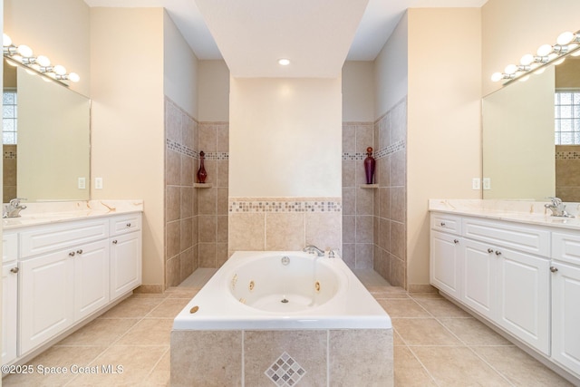 bathroom with tile patterned floors, vanity, and tiled bath