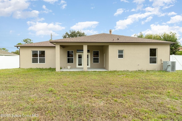 rear view of property with a lawn, a patio area, and cooling unit