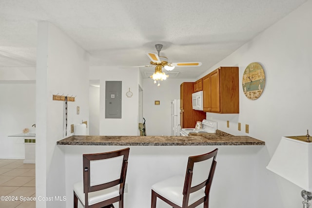 kitchen featuring a textured ceiling, white appliances, ceiling fan, light tile patterned floors, and electric panel