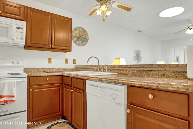 kitchen with a textured ceiling, ceiling fan, white appliances, and sink